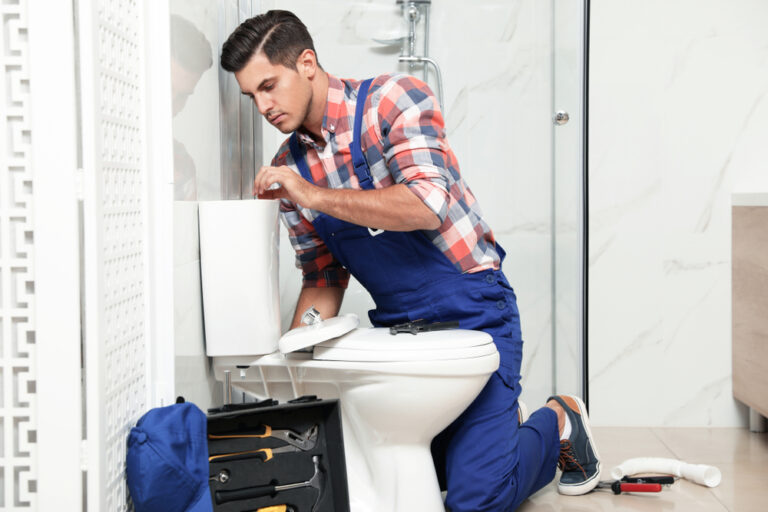 O&M Plumbing Professional repairing a toilet seat.